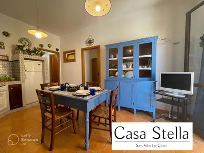 a dining room with a table and a blue cabinet at Casa Stella San Vito Lo Capo in San Vito lo Capo