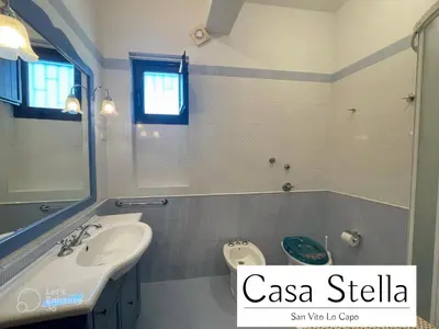 a bathroom with a sink and a toilet and a mirror at Casa Stella San Vito Lo Capo in San Vito lo Capo