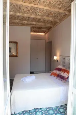 a bedroom with a white bed and a ceiling at Alle Absidi della Cattedrale in Palermo