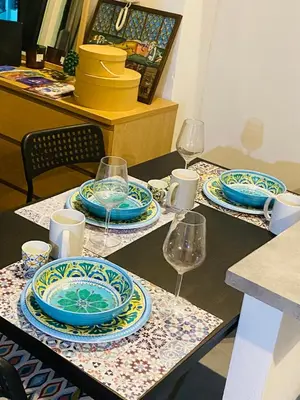 a table with plates and wine glasses on it at casetta della cattedrale in Palermo