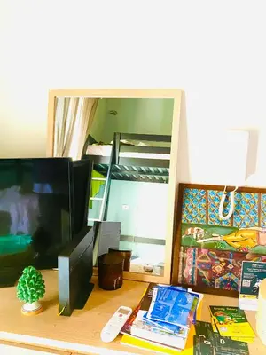 a desk with a television and a mirror and a bed at casetta della cattedrale in Palermo