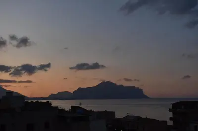 a sunset over the ocean with a mountain in the distance at ROOM VISTAMARE PALERMO in Palermo