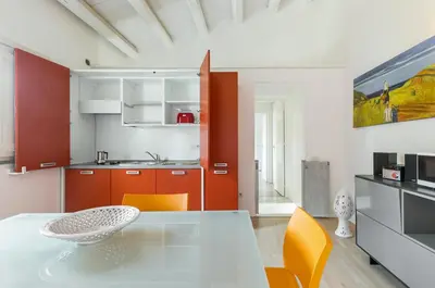 a kitchen with a dining table and orange chairs at GuestHost - Palermo Modern Apartment with Swimming Pool in Palermo