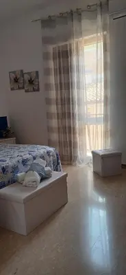 a bedroom with a bed and a large window at Le Cummari in Castellammare del Golfo