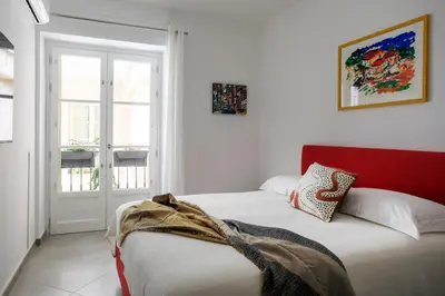 a bedroom with a bed with a red headboard at Tomasi Apartment Palermo in Palermo