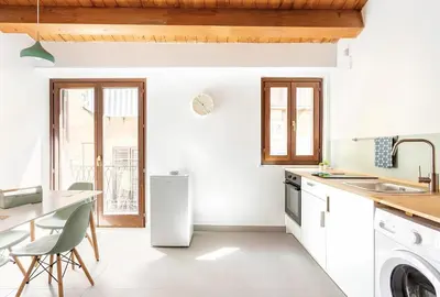 a kitchen with white appliances and a table and chairs at Vicolo del Capo in Palermo