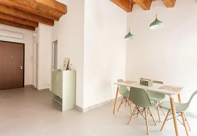 a dining room with a table and chairs and a refrigerator at Vicolo del Capo in Palermo