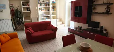a living room with a red chair and a television at Daysin Apartment in Palermo