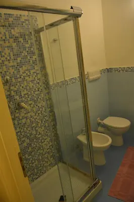 a bathroom with a glass shower with a toilet at Daysin Apartment in Palermo