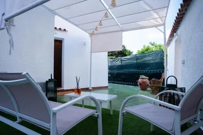 a patio with white chairs and a table and a view at Ischia suite in Termini Imerese