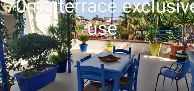 a blue table and chairs on a balcony with plants at La Casa di Chico in Mondello