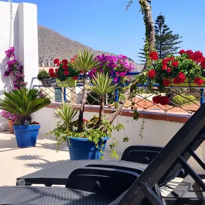 a patio with potted plants and a table and chairs at La Casa di Chico in Mondello