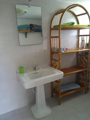 a bathroom with a sink and a mirror and shelves at La Casa di Chico in Mondello