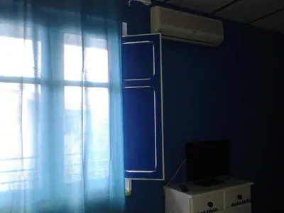 a blue room with a window and a television at La Casa di Chico in Mondello