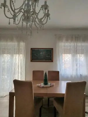 a dining room with a table and chairs and a chandelier at Rosdani Apartment in Palermo