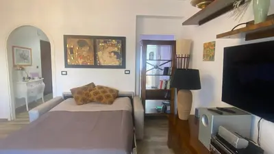 a living room with a bed and a tv and a room at Rosdani Apartment in Palermo