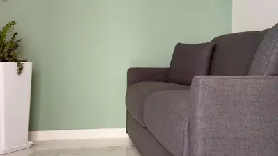 a gray couch in a living room with a plant at Palazzo Maqueda in Palermo