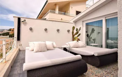 a balcony with two white pillows and a table on it at 3 Bedroom Gorgeous Home In Trappeto in Trappeto