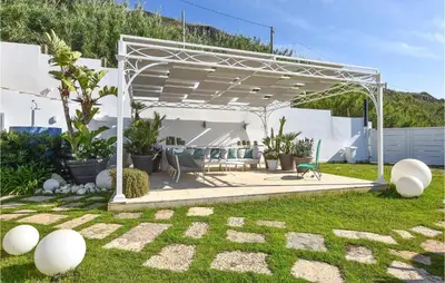 a white pergola in a yard with plants at 3 Bedroom Gorgeous Home In Trappeto in Trappeto