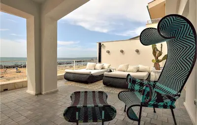a living room with a couch and a chair on a patio at 3 Bedroom Gorgeous Home In Trappeto in Trappeto