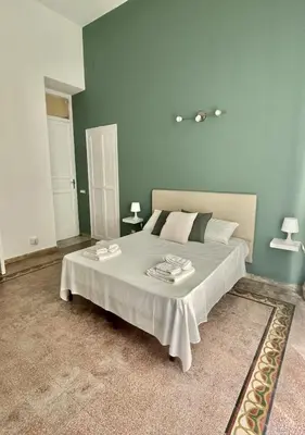 a bedroom with a large bed with green walls at Stazione Armò in Palermo