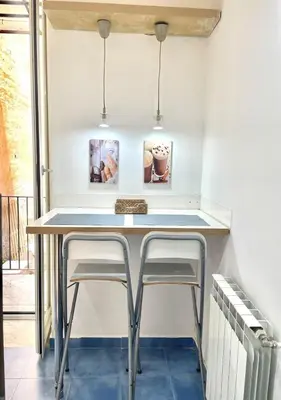 a small kitchen with a table and two stools at Stazione Armò in Palermo