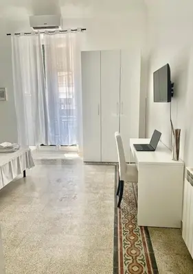 a white room with a desk with a laptop on it at Stazione Armò in Palermo