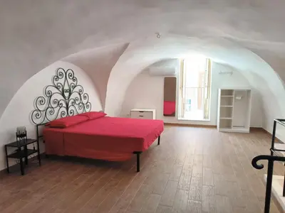 a bedroom with a red bed in an attic at La Volta di Gatto in Palermo