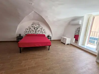 a bedroom with a red bed in a room at La Volta di Gatto in Palermo
