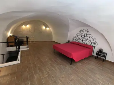 a room with a red bed in a tunnel at La Volta di Gatto in Palermo