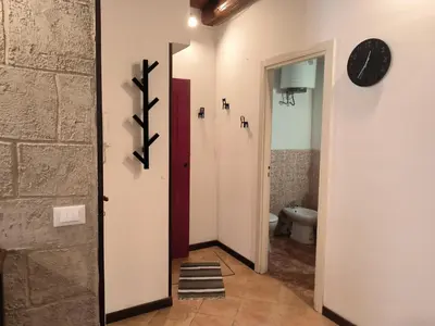 a hallway with a toilet and a clock on a wall at La Volta di Gatto in Palermo
