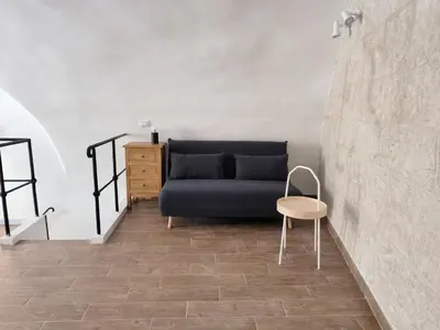 a living room with a blue couch and a chair at La Volta di Gatto in Palermo