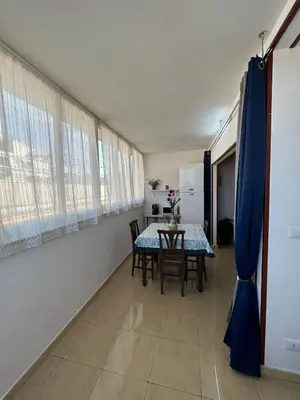 a dining room with a table and chairs in a room at Le Trottole Apartment in Palermo