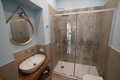 a bathroom with a shower and a sink and a mirror at Domus Maqueda - Pressi Teatro Massimo in Palermo