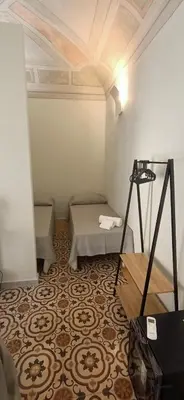 a small room with a bed and a table at Domus Maqueda - Pressi Teatro Massimo in Palermo