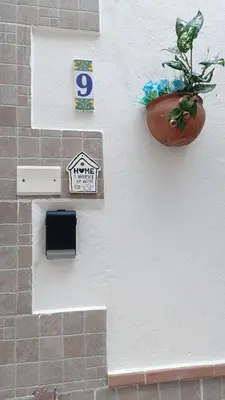 a wall with a potted plant and a sign on it at Casa Diema in Palermo