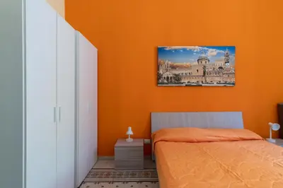 a bedroom with a bed and a desk and a window at CORNER ROME appartamento in Palermo
