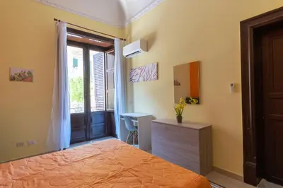 a bedroom with a desk and a bed and a window at CORNER ROME appartamento in Palermo