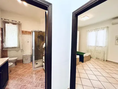 a large bathroom with a shower and a toilet at Villa Genova in Carini