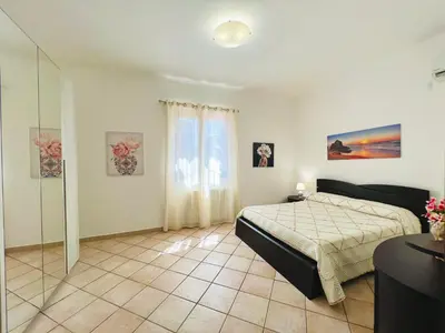 a bedroom with a bed and a glass wall at Villa Genova in Carini