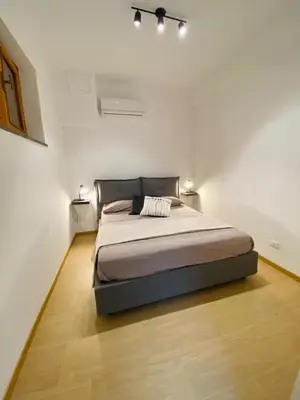 a bedroom with a large bed in a white room at Artemide 15 New Apartment near Mondello in Palermo