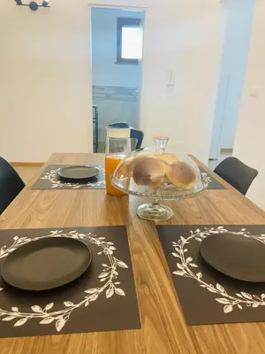a wooden table with two plates and a glass bowl of bread at Artemide 15 New Apartment near Mondello in Palermo