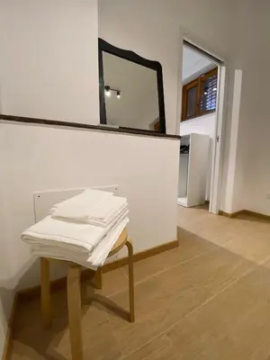 a pile of white towels on a table with a mirror at Artemide 15 New Apartment near Mondello in Palermo
