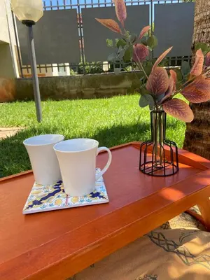 two cups and a vase on a wooden table at Artemide 15 New Apartment near Mondello in Palermo