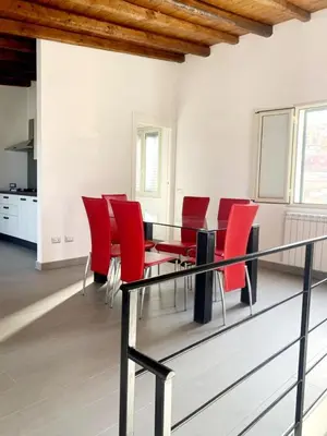 a dining room with red chairs and a glass table at Antica Dimora in Termini Imerese