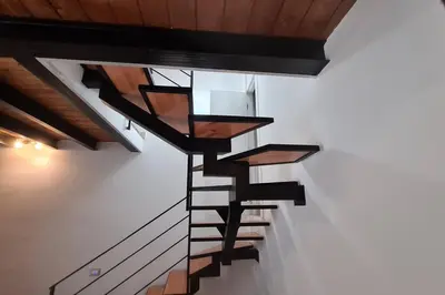 a spiral staircase in a room with wooden ceilings at Antica Dimora in Termini Imerese