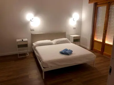 a bedroom with a white bed with two night stands at TOURIST HOUSE Le casette di Sofì in Bagheria