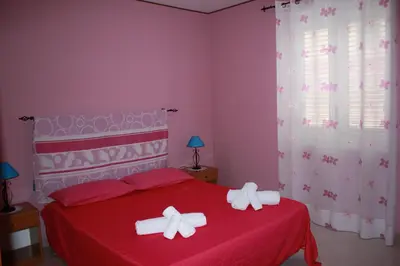a bedroom with a red bed with bows on it at GB Case Vacanze Sicilia in Balestrate