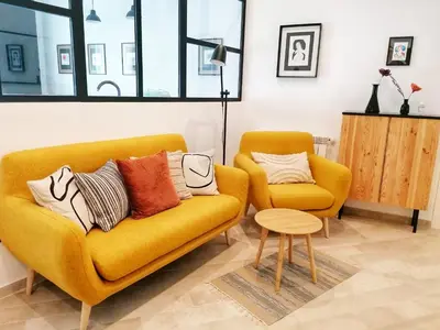 a living room with a yellow couch and a chair at I Canti Comfort Rooms in Palermo