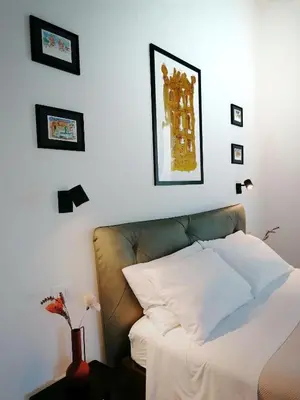 a bedroom with a white bed and a couch at I Canti Comfort Rooms in Palermo